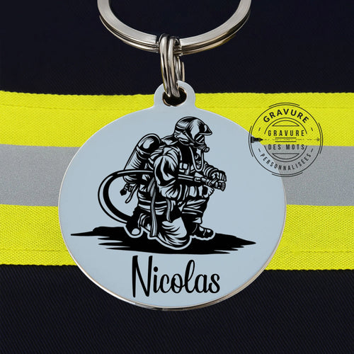 porte clé avec gravure d' un pompiers sous ARI tenant une lance incendie