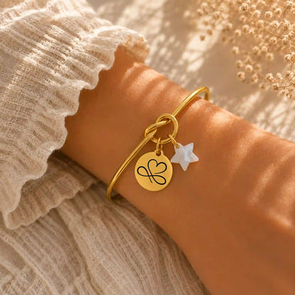 bracelet en jonc couleur or avec gravure personnalisée et une etoile en nacre