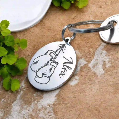 Un porte-clé rond en métal avec un dessin gravé de gants de boxe - vue alternative